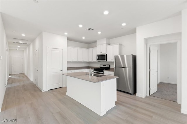 2733 Avril Point St, Las Vegas, NV 89156 - kitchen featuring a sink, light wood-style flooring, appliances with stainless steel finishes, and white cabinetry