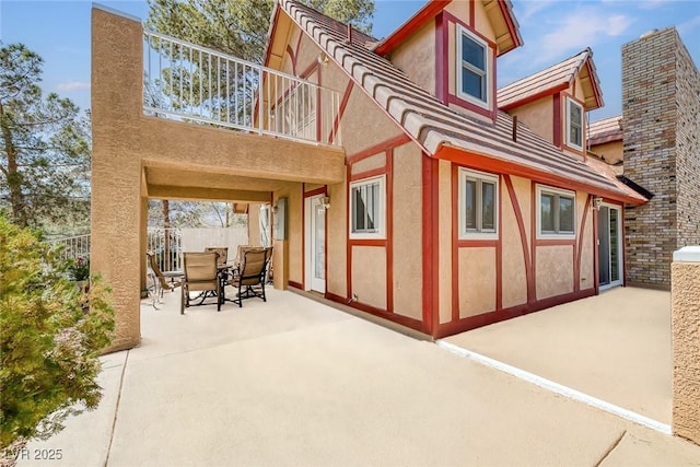 view of patio with outdoor dining area and a balcony