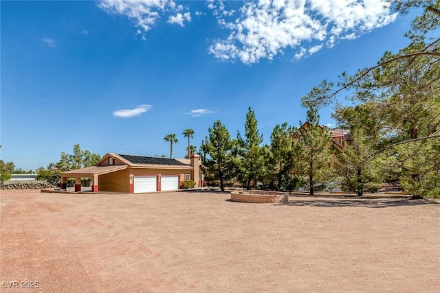 view of front of house featuring an attached garage, a chimney, and driveway