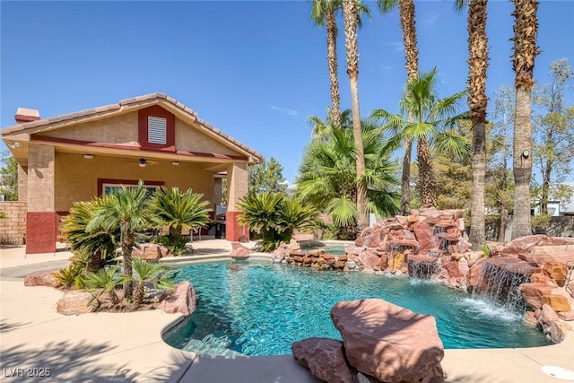 view of swimming pool featuring ceiling fan, a pool with connected hot tub, and a patio area