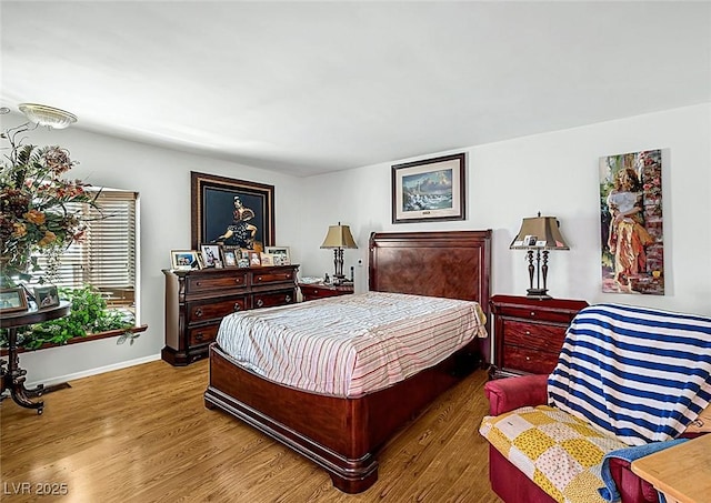 bedroom with baseboards and wood finished floors