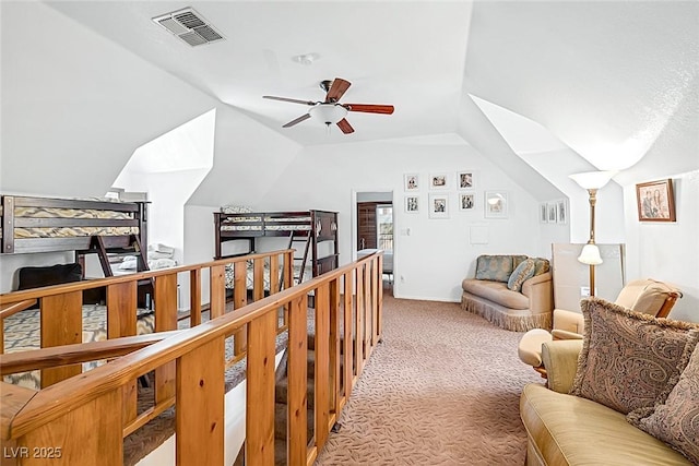 interior space featuring visible vents, carpet, ceiling fan, and vaulted ceiling