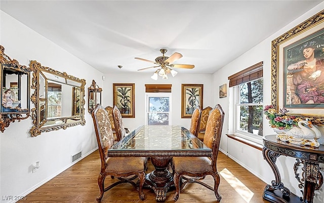 dining space featuring baseboards, ceiling fan, visible vents, and wood finished floors