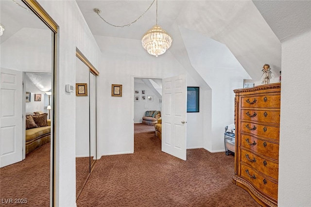 hall featuring carpet flooring, baseboards, an inviting chandelier, and lofted ceiling