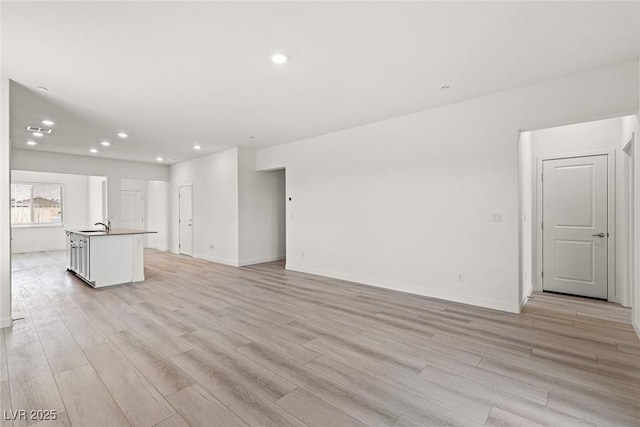 2739 Avril Point St, Las Vegas, NV 89156 - unfurnished living room featuring baseboards, recessed lighting, and light wood-type flooring