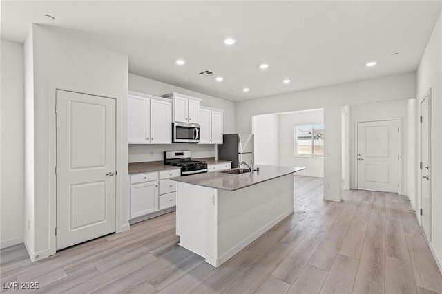 2739 Avril Point St, Las Vegas, NV 89156 - kitchen with visible vents, a sink, stainless steel appliances, a kitchen island with sink, and light wood-type flooring
