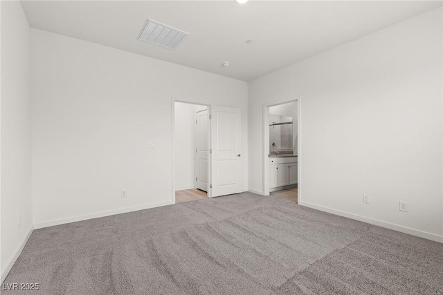 2739 Avril Point St, Las Vegas, NV 89156 - unfurnished bedroom featuring light colored carpet, connected bathroom, baseboards, and visible vents