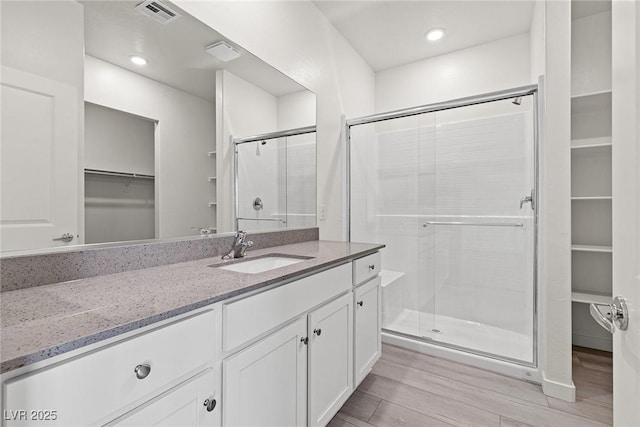 2739 Avril Point St, Las Vegas, NV 89156 - full bath with visible vents, a shower stall, vanity, wood finished floors, and a spacious closet