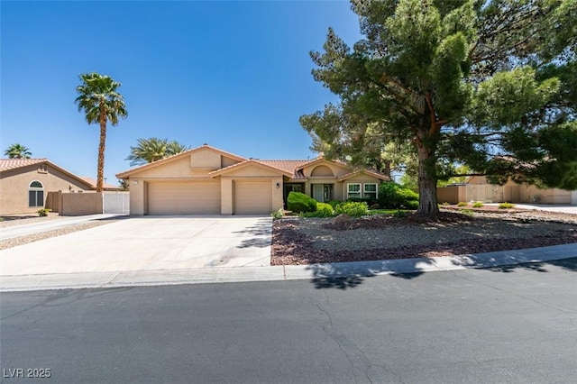 view of front of home with stucco siding, fence, driveway, and a garage
