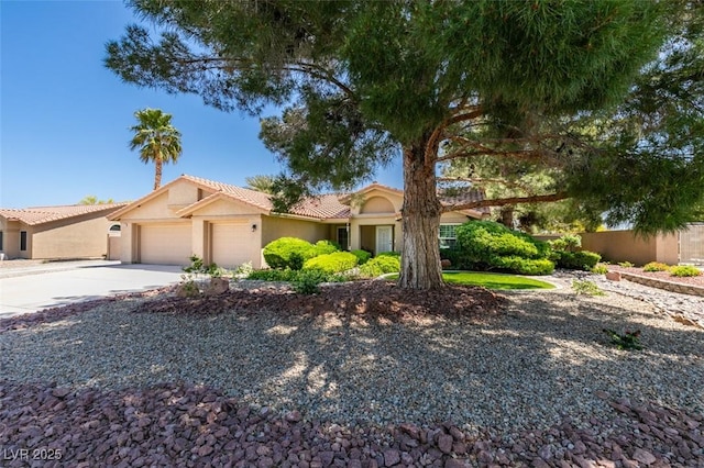 single story home with an attached garage, stucco siding, a tile roof, and concrete driveway