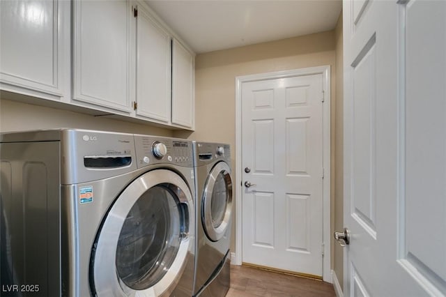laundry room featuring cabinet space, light wood-type flooring, and independent washer and dryer