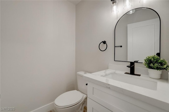 bathroom featuring vanity, baseboards, and toilet