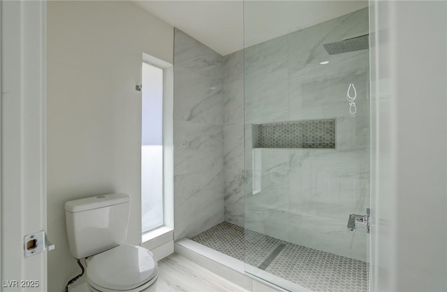 full bathroom with toilet and a marble finish shower