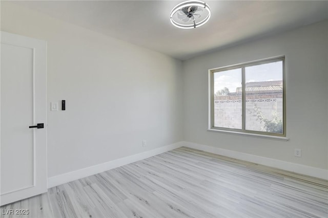 unfurnished room featuring baseboards and light wood finished floors