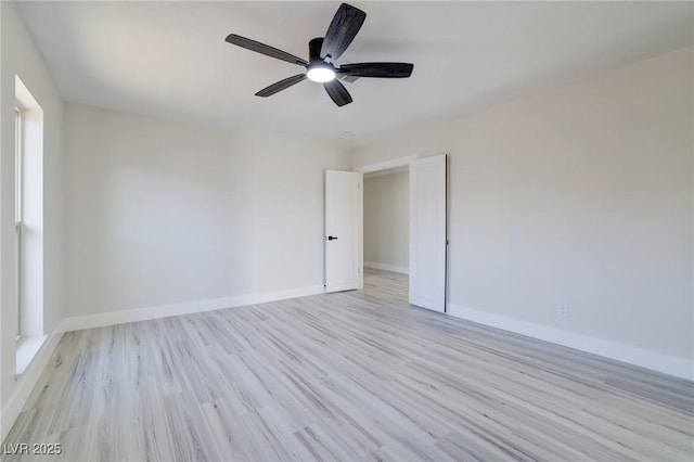 unfurnished room featuring ceiling fan, baseboards, and light wood-type flooring