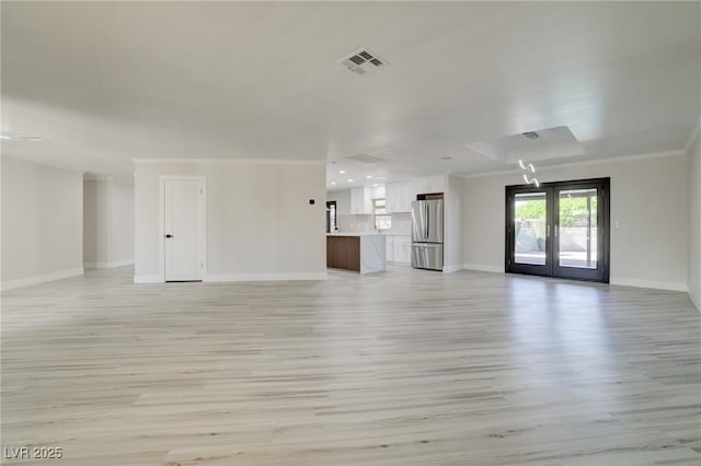 unfurnished living room with visible vents, ornamental molding, baseboards, french doors, and light wood-style flooring
