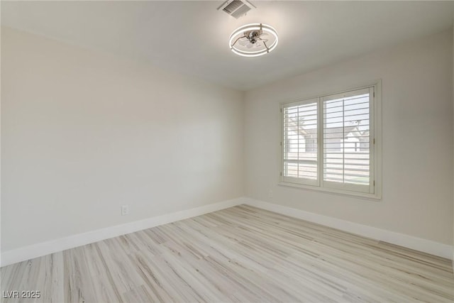 unfurnished room with baseboards, wood finished floors, and visible vents