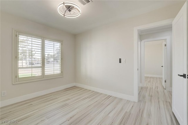 empty room with visible vents, baseboards, and wood finished floors