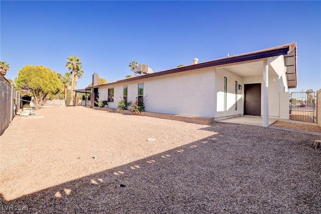 back of property featuring fence, a patio, and stucco siding
