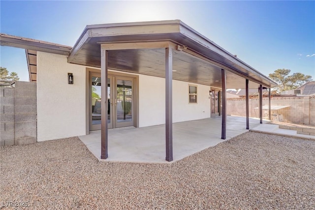 back of house featuring fence, a patio, stucco siding, and french doors