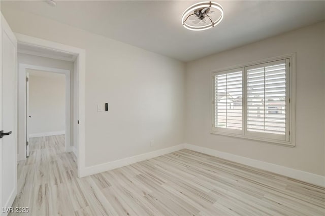 unfurnished room with baseboards and wood finished floors
