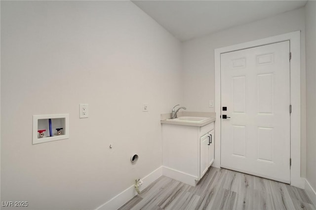 clothes washing area with washer hookup, hookup for a gas dryer, light wood-type flooring, a sink, and baseboards
