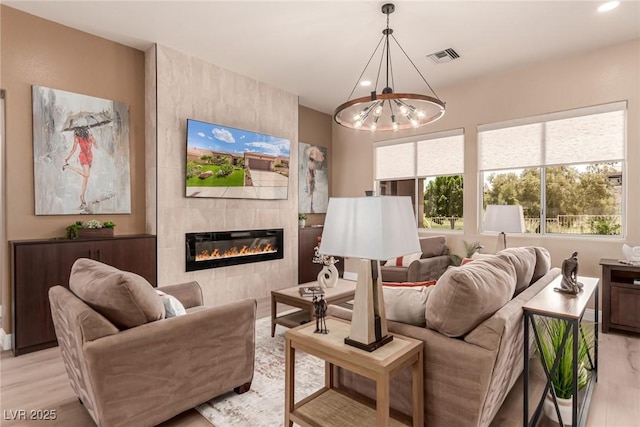 10713 Shoalhaven Dr, Las Vegas, NV 89134 - living area featuring a chandelier, light wood finished floors, a tile fireplace, and recessed lighting