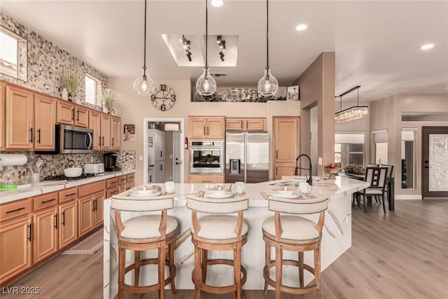 10713 Shoalhaven Dr, Las Vegas, NV 89134 - kitchen with appliances with stainless steel finishes, a sink, light wood-style flooring, a kitchen breakfast bar, and recessed lighting