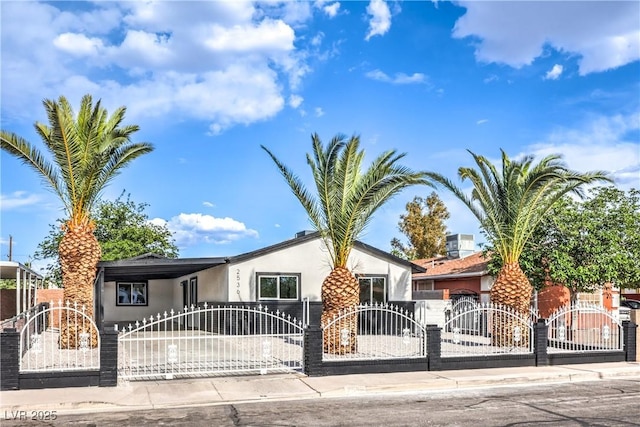 view of front of house featuring a gate, a fenced front yard, and stucco siding