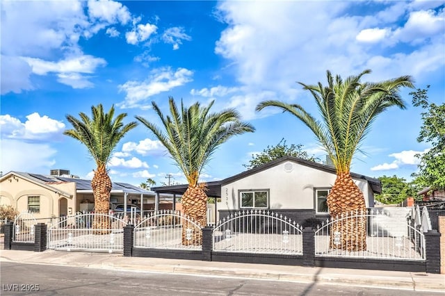view of front of property featuring a gate, a fenced front yard, and stucco siding
