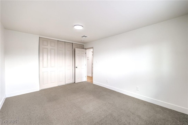 unfurnished bedroom with baseboards, visible vents, carpet, and a closet