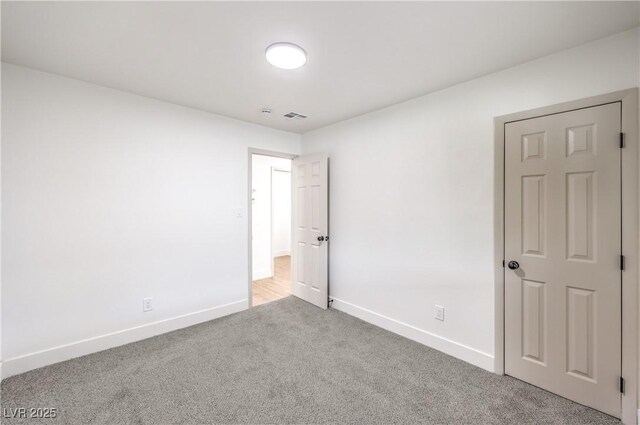unfurnished bedroom with visible vents, carpet flooring, and baseboards