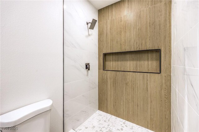 full bath featuring a tile shower and toilet