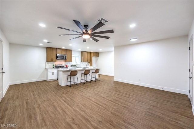 kitchen with ceiling fan, appliances with stainless steel finishes, recessed lighting, baseboards, and wood finished floors