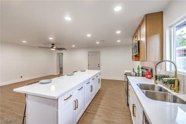 kitchen with recessed lighting, a sink, light countertops, and stainless steel appliances