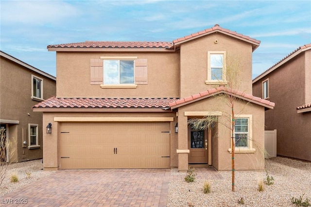 mediterranean / spanish house with stucco siding, a tile roof, and a garage