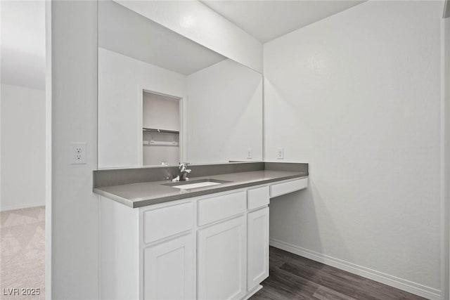bathroom with baseboards, wood finished floors, and vanity