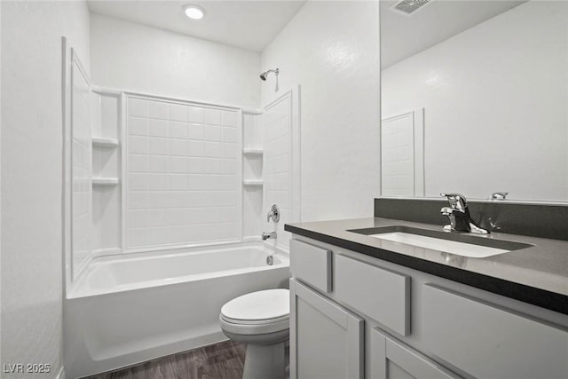 full bathroom featuring visible vents, vanity, wood finished floors, toilet, and  shower combination