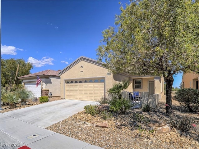 view of front of home with stucco siding, concrete driveway, and a garage