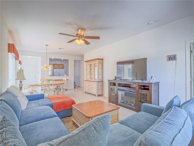 living room with a chandelier, light carpet, and ceiling fan