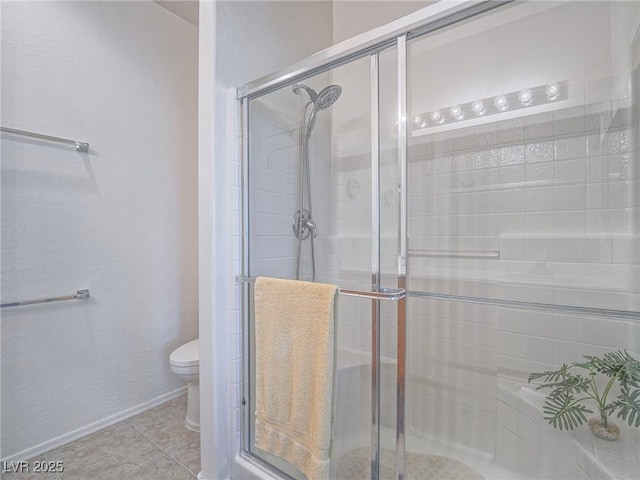 full bath featuring toilet, a shower stall, and tile patterned floors