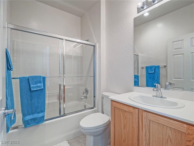 full bath with toilet, combined bath / shower with glass door, vanity, and tile patterned flooring