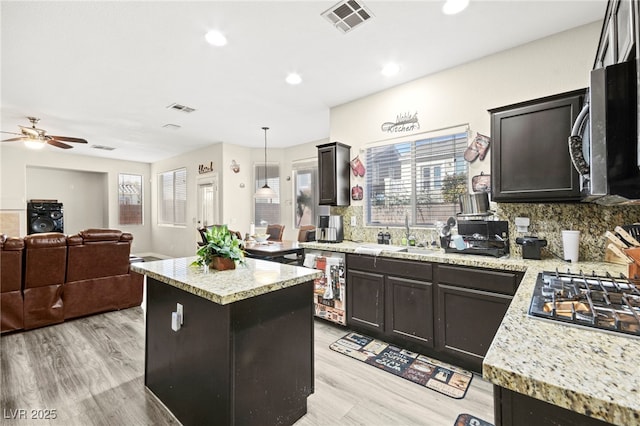 kitchen with light wood-style floors, visible vents, appliances with stainless steel finishes, a sink, and wine cooler