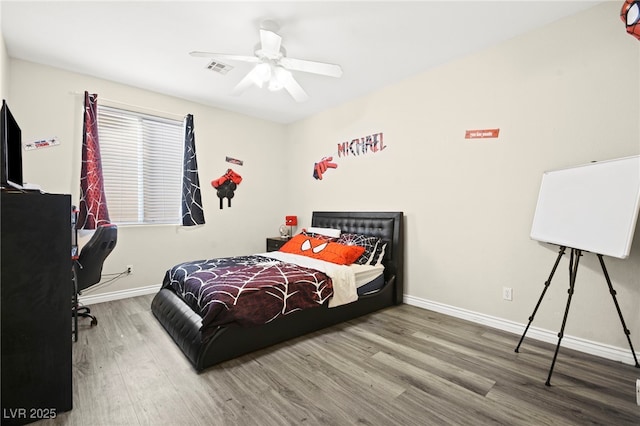 bedroom featuring baseboards, ceiling fan, and wood finished floors