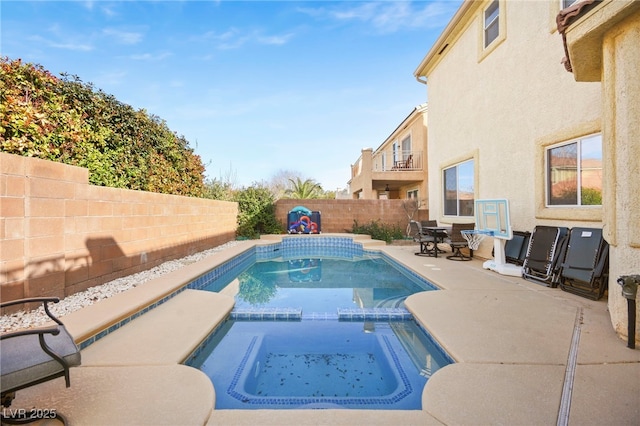 view of swimming pool with a patio, a pool with connected hot tub, and a fenced backyard