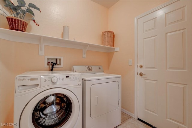 laundry area featuring light tile patterned floors, laundry area, and washer and clothes dryer
