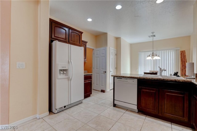 kitchen featuring a sink, light tile patterned floors, a notable chandelier, recessed lighting, and white appliances