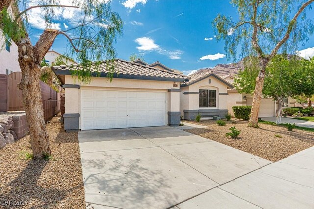 71 Blaven Dr, Henderson, NV 89002 - mediterranean / spanish-style home featuring stucco siding, a tiled roof, concrete driveway, a garage, and fence