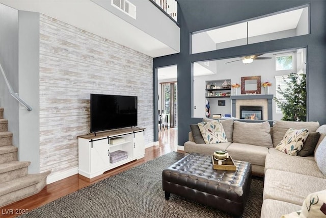 1861 Windward Ct, Henderson, NV 89012 - living room with ceiling fan, visible vents, a tiled fireplace, wood finished floors, and stairs