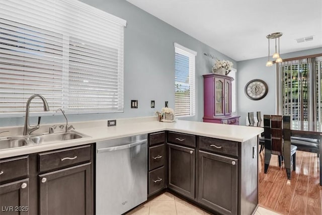 1861 Windward Ct, Henderson, NV 89012 - kitchen featuring stainless steel dishwasher, dark brown cabinets, a sink, light countertops, and a peninsula
